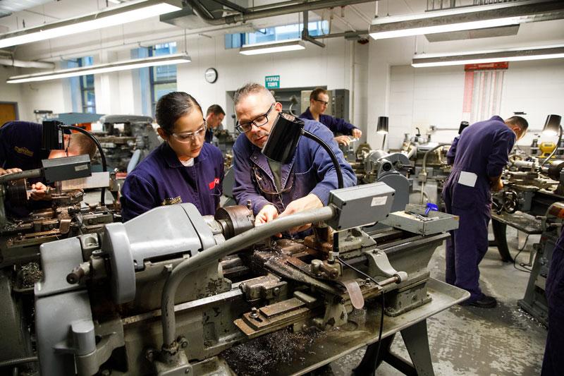 a cadet with an instructor in the machine tool lab